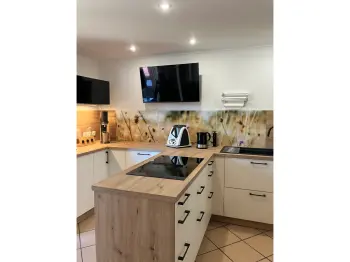 Gesamtansicht einer T-förmigen Küche in Holzoptik