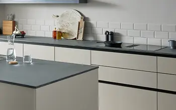 Nahaufnahme einer Küchenarbeitsplatte in Grau auf einer Küche mit cremefarbenen Fronten.