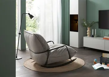 Hellgrauer Schaukelstuhl mit schwarzem Gestell.