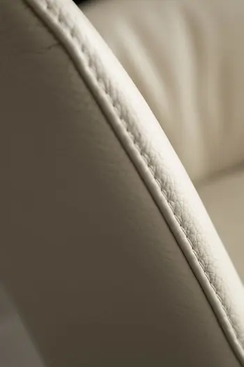 Ansicht der Naht eines Polsterstuhls mit Lederbezug in beige aus der Nähe.