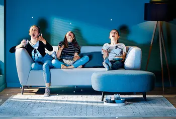 Familie auf Couch isst Popcorn