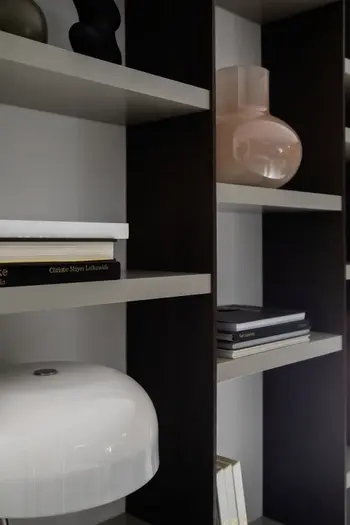 Moderne Regalwand mit versetzten grauen Regalböden.