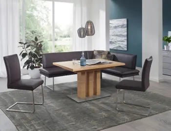 Sie sehen eine Eckbankgruppe mit zwei Stühlen im grauen Leder, dazu ein Eichentisch