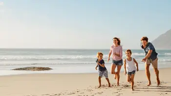 Fröhliche Familie, die am Strand laufen.