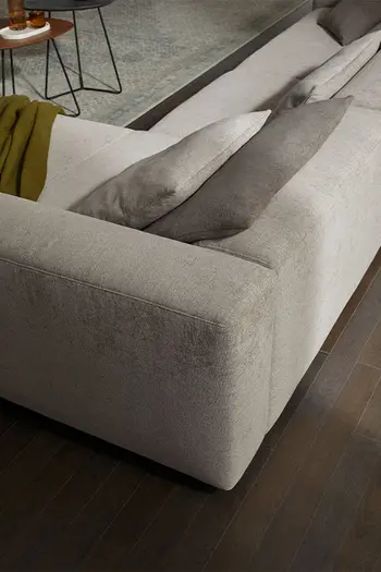 Beiges Design Ecksofa mit niedriger Rückenlehne von hinten.