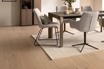 Schalenstühle in beigem Stoff mit Metallgestell, eines als Drehstuhl an einem dunklen Holzesstisch.