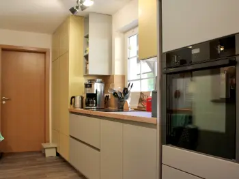 Gesamtansicht einer gelben, grifflosen Küche