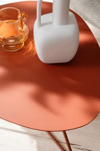 Roter Beistelltisch mit zwei Vasen.