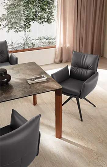 Elegantes Esszimmer mit Esstisch und Esszimmerstühlen in dunkelgrauem Leder.