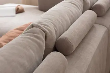 Rückansicht eines grauen Sofas mit großen gemütlich gepolsterten Rückenkissen, dahinter befinden sich runde Kopfstützen.