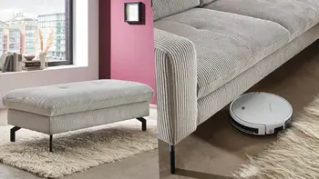 Hellgrauer Stoffhocker und Stoffsofa mit Platz für einen Staubsaugerroboter. 