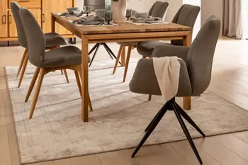 Moderne Esszimmerstühle mit und ohne Armlehne in grau, mit Holzgestell oder schwarzem Metallgestell um einen Massivholzesstisch.