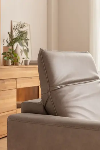 Graues Ledersofa, bei dem die Kopflehne nach oben geklappt ist.