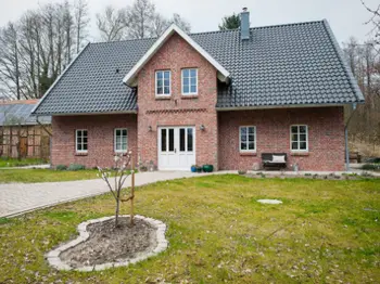 Landhaus mit großer Eingangstür und dunklem Dach