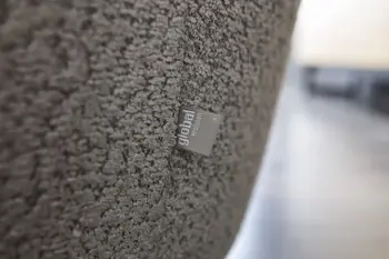 Grauer Boucle Stoff in Nahaufnahme mit Global Wohnen Label.