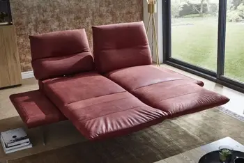 Rotes Ledersofa, bei dem die Sitzflächen ausgezogen sind und nach vorne zu einer größeren Liegefläche gedreht.