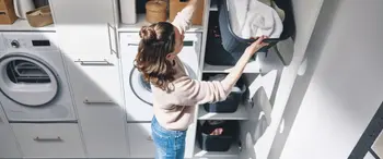Frau mit Wäsche im Hauswirtschaftsraum mit cleveren Schranklösungen