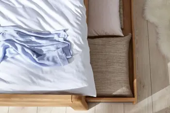 Schublade unter einem Massivholzbett mit Stauraum.