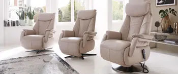 Drei cremefarbene Relaxsessel mit unterschiedlichen Fußgestellen in einem hellen Raum.