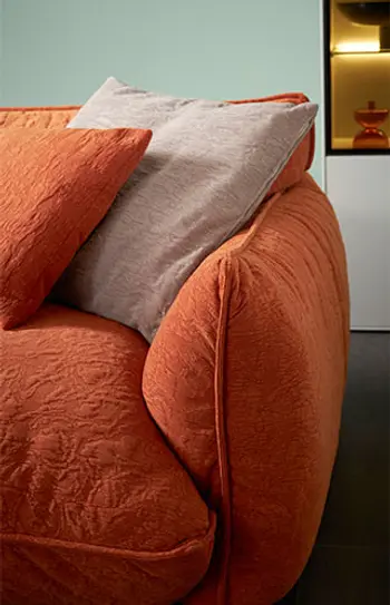 Armlehne eines bequem gepolsterten orangen Bigsofas.