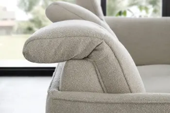 Seitliche Aufnahme eines beigen Sofas mit klappbaren Kopfstützen.
