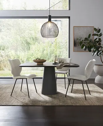 Minimalistisch eingerichteter Essbereich mit schwarzem, quadratischen Esstisch und weißen Stoffstühlen.