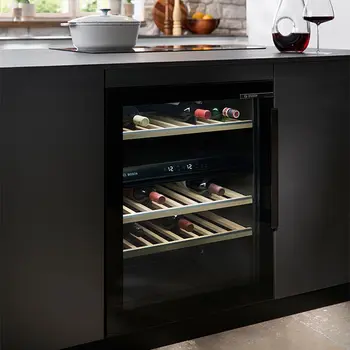 Weinkühlschrank in einer schwarzen Designküche in einem sanierten Bauernhaus.