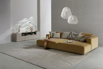 Gelbes Design Sofa mit großer Liegefläche und beiges Design Sideboard in einem Bungalow.