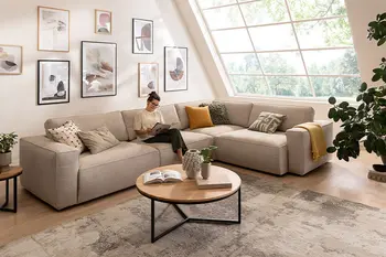 Helles Wohnzimmer mit beigem Ecksofa und rundem Couchtisch.