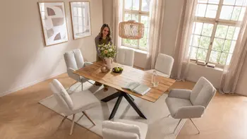 Helles Esszimmer mit großem Esstisch und sechs modernen Esszimmerstühlen in beigem Stoff.