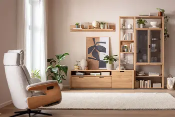 Harmonisch eingerichtetes Wohnzimmer mit moderner Wohnwand aus Eiche, Relaxsessel und beigem Teppich.
