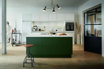 Designküche mit waldgrüner Kücheninsel und weißer Küchenzeile dahinter.