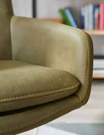 Sitzfläche eines grünen Leder Armlehnstuhls im Detail.